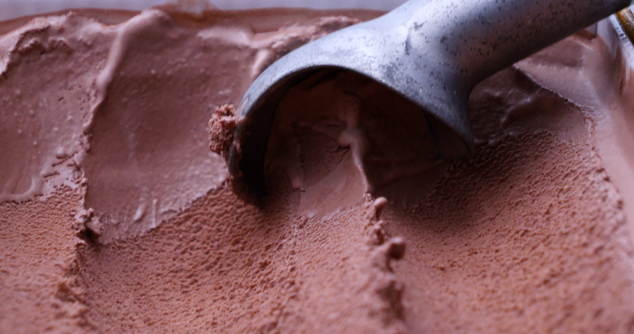 Front view of a stainless steel spoon scooping up chocolate ice cream. Royalty-Free Stock Footage #1097840687