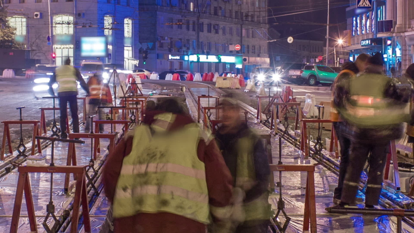 Tram rails at the stage of their installation and integration into concrete plates on the road night timelapse. Filling by liquid resin for reduction of vibration and noice. The process of