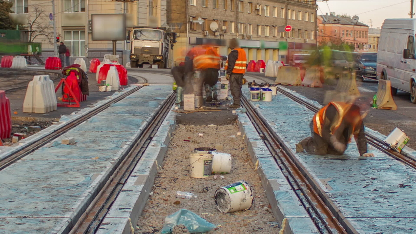 Tram rails at the stage of their installation and integration into concrete plates on the road timelapse. Filling by liquid resin for reduction of vibration and noice. The process of reconstruction of