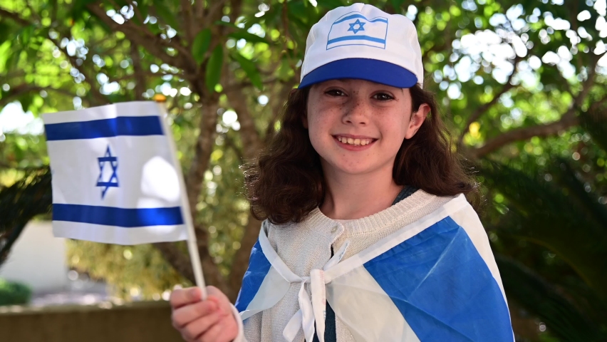 Happy Israeli Jewish girl (female age 08) waving the national flag of Israel on Israel Independence Day. Real people. Copy space Royalty-Free Stock Footage #1097847883