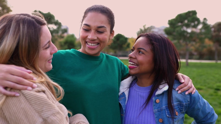 Friendly group of united female friends laughing while hugging each other in the city park. Unity lifestyle and international friendship concept Royalty-Free Stock Footage #1097855375