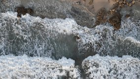 Top down eagle eye view of sea waves crashing on the beach. Film shot for intro with the concept of peace and quiet