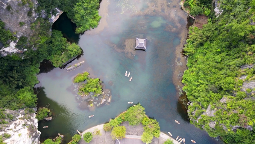 Ascending Birds Eye View Over Trang An Temple In Water Surrounded By Jungle In Vietnam. Aerial Rising Shot