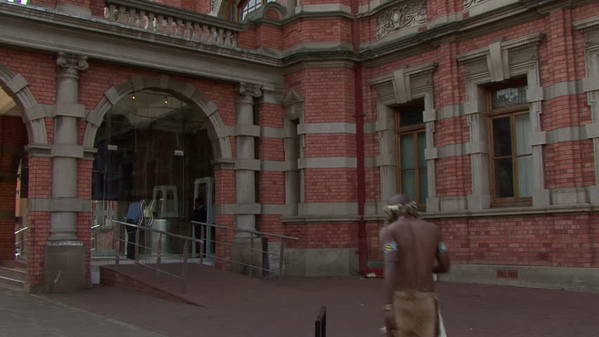 indigenous man with traditional clothing entering city hall