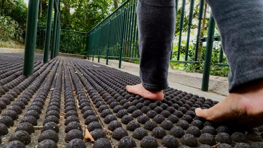 A woman walks the pebble walking trail for health.