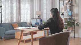 Asian Businesswoman Wearing Business Suit Having Video Call With Her Colleague On Computer While Working At Home
