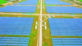 Aerial view from a drone flying over a large solar farms. clean energy technology and energy crisis concept. electricity generation industry for households. Southeast asia. 4K footage. 
