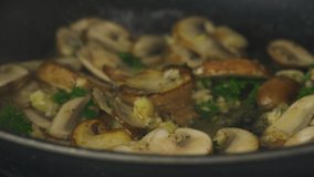 Video. Mushrooms are fried in a pan with parsley and spices. Delicious, nutritious meal. Recipes for restaurant and home cooking. There are no people in the video.