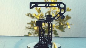 A black metal camera cage on a rotating stand, slow motion, close up shot, 4K