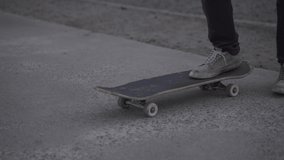 Close up skateboard. Skater foot on the board starts riding and departs on concrete floor. Slow motion video