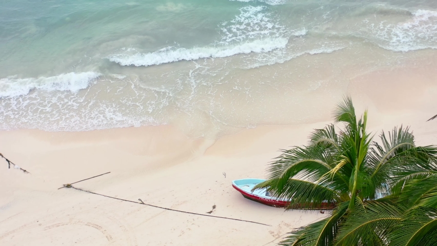 static tripod aerial of turquoise blue waves crashing on empty castaway island beach