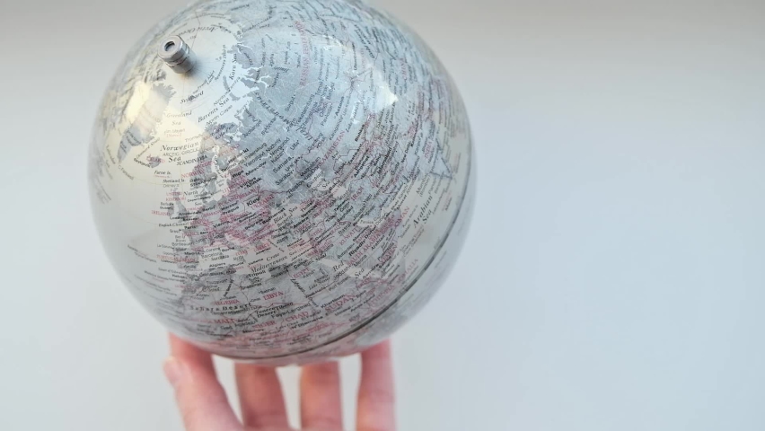 Hand rotates a gray Globe and selects a random point on the map. Manuscript globe, representing 3-dimensional form of the world map. High quality FullHD footage. 