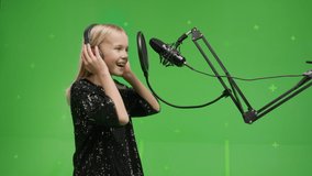 Portrait of young girl singing into a studio microphone on a green screen background. - Powered by Shutterstock - Get 15% off with code: PIKWIZARD15