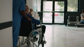 Nurse helping man in wheelchair to meet with family in clinic lobby, old patient dealing with chronic impairment at facility. Mother and child visiting senior person in waiting room. - Powered by Shutterstock - Get 15% off with code: PIKWIZARD15
