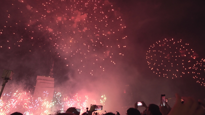 A lively crowd of people celebrating the New Year with a stunning fireworks display. The video captures the excitement and joy of the moment as the vibrant colors and lights fill the night sky.
 Royalty-Free Stock Footage #1097897537