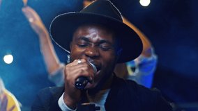 Close-up portrait of energetic happy African singer performing music event singing with microphone vibing. Attractive upbeat man making party for young positive people hanging out on fest. - Powered by Shutterstock - Get 15% off with code: PIKWIZARD15