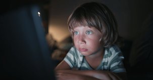 Close up of boy 4-5 years afraid child while using a tablet in living room, Small child hold pad computer surfing not safe content online internet at home. child abuse concept, child on social media