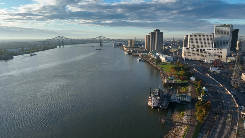 Mississippi River at New Orleans Louisiana. Aerial during golden hour reveals Huey P Long Bridge and downtown, waterfront area.