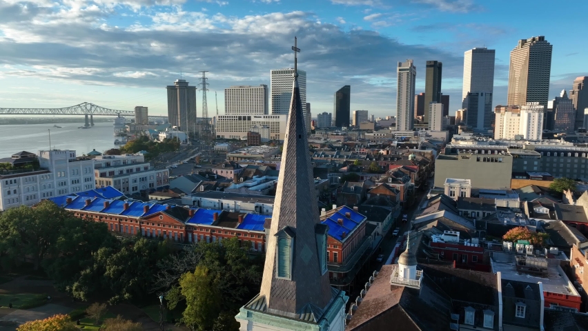 Aerial orbit of steeple at St Louis Cathedral reveals New Orleans French Quarter and skyline, Mississippi River.