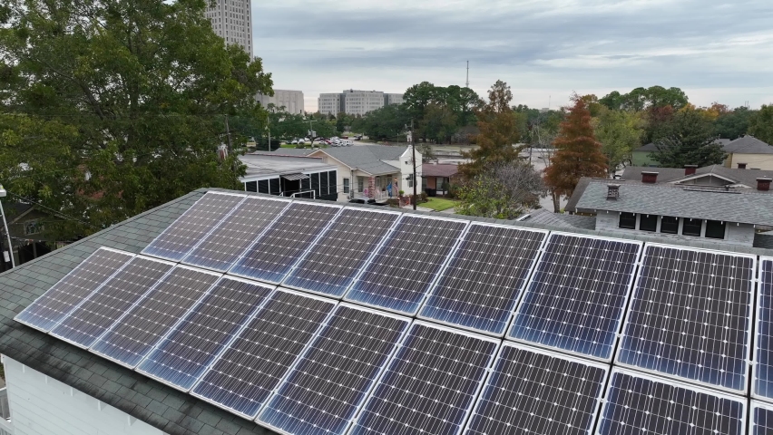 Rooftop solar panels on home in Baton Rouge Louisiana. Renewable energy theme in poor city community in Deep South USA. Royalty-Free Stock Footage #1097927585