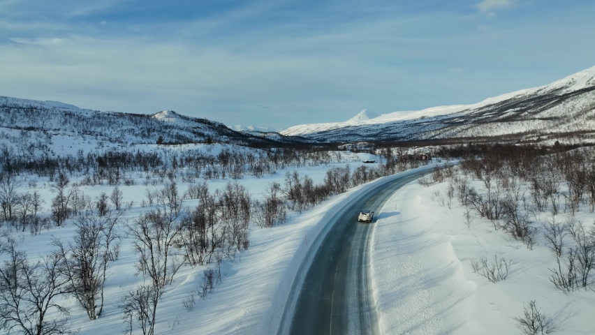Aerial view following a car driving in the boreal nature of the Arctic region Royalty-Free Stock Footage #1097928375