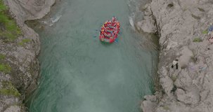 Rafting down a mountain river. Tourists raft down a beautiful mountain gorge, Raft, rocks, splashing rapids. Aerial view. Slow motion 120 fps, ProRes 422, 10 bit ungraded DJI D-LOG video
