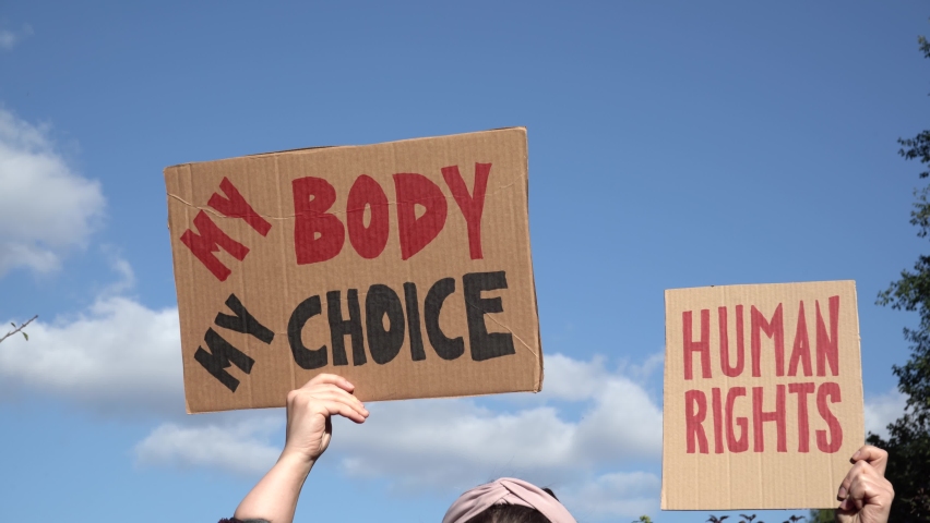Protesters holding signs with slogans My Body My Choice and Human rights. People with placards supporting abortion at protest rally demonstration.