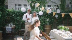 Mature bride and groom toasting with their daughters at wedding reception outside in the backyard. - Powered by Shutterstock - Get 15% off with code: PIKWIZARD15
