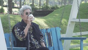 old elderly elder senior woman drinking coffee relaxing in flower garden park - Powered by Shutterstock - Get 15% off with code: PIKWIZARD15