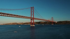 The 25 de Abril Suspension Bridge over Tagus river in Lisbon, the capital of Portugal, with busy traffic on the bridge during sunset hours.