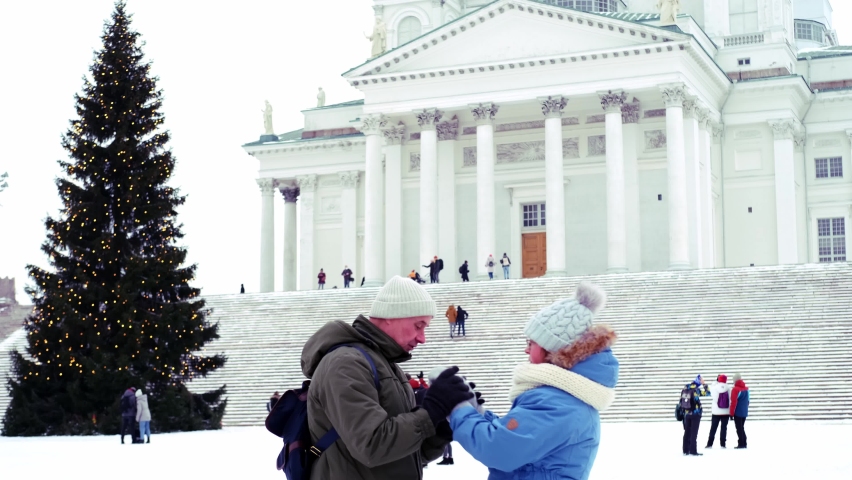 mature couple near Helsinki Cathedral and Statue Of Emperor Alexander II Of Russia, people walking along winter street, concept holiday, pre-holiday chores citizens, Helsinki, Finland - January 2022