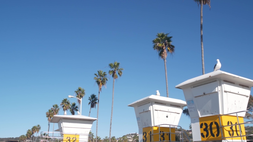Lifeguard stand or life guard tower hut, surfing safety on California beach, USA. Summer pacific ocean aesthetic. Rescue station, coast lifesavers wachtower or house, palm trees in La Jolla, San Diego