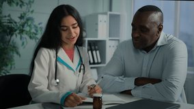 Doctor woman therapist caregiver filling health test results in notebook write pills prescription help african man listen recommendation male sick patient take medicine healthcare aid at clinic office - Powered by Shutterstock - Get 15% off with code: PIKWIZARD15