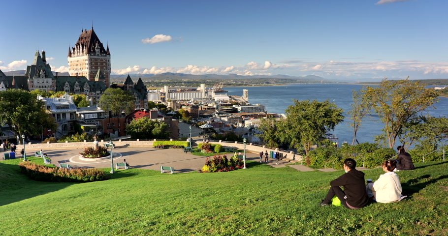 Quebec City, Canada - September 26, 2021: People sit on the grass of the Quebec Citadel overlooking the downtown city skyline and the St. Lawrence River in summer