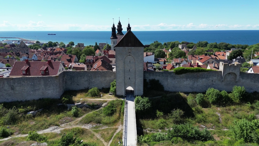 Aerial drone footage flying over the town on the Swedish island Gotland, Visby located in the Baltic Sea. Fortified wall in the Gotland island. Ancient medieval city walls, medieval Sweden city.  Royalty-Free Stock Footage #1097954345