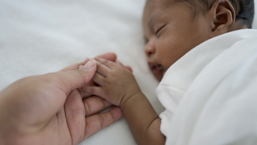 Parent hands holding newborn african black baby fingers, Close up mother's hand holding their new born baby. Together love family healthcare and medical, father's day and mother's day concept Royalty-Free Stock Footage #1097963341