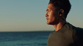 Fitness, running and man with earphones by beach, runner listening to music or podcast for motivation. Sports, sea and run with focus, profile and exercise with radio, wellness and ocean mockup. - Powered by Shutterstock - Get 15% off with code: PIKWIZARD15