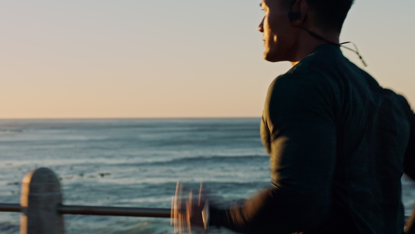 Man, beach and sunset running, exercise and cardio training with music for motivation, fitness mindset and marathon goals. Runner, athlete and guy workout at sea, nature and ocean for sports wellness | Shutterstock HD Video #1097975283