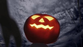 Glowing pumpkin effigy in a corn field against the background of running clouds at night. Halloween concept. - Powered by Shutterstock - Get 15% off with code: PIKWIZARD15