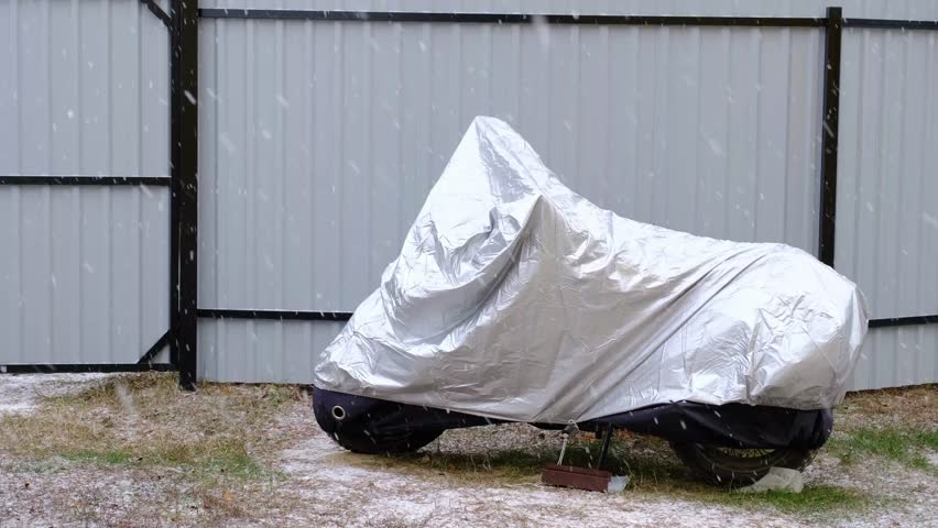 Motorcycle storage under an awning in winter outdoor. Protective awning, under the snow	
