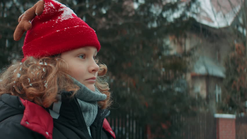 Portrait of cute little kid boy puts a letter with his Christmas wishes addressed to Santa Claus, Notrh Pole into the mailbox in the street