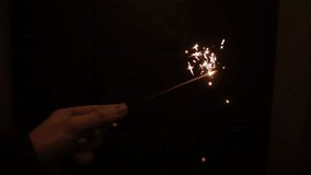Sparkler pyrotechnics with black background in slow motion 500 fps. Sparkling new years eve party, festive pyro for video or effect use for sprakling glimming golden effect.