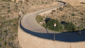 Young fit women athlete on road bicycle climb uphill on serpentine switchback . Snake road Bird eye view. Sport activity motivation video. Spain