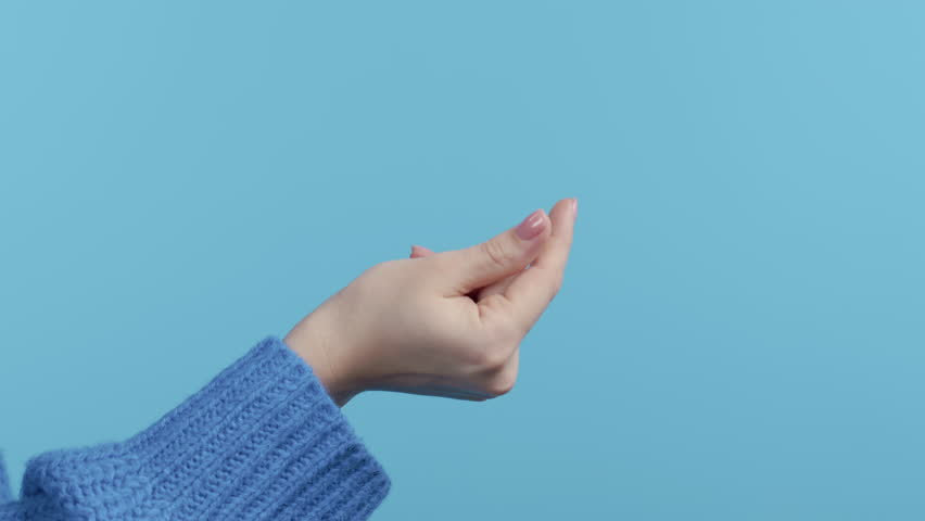 Unrecognizable woman snaps fingers on blue studio background. Snapping to make sound, bring people attention, body language. Royalty-Free Stock Footage #1098026549