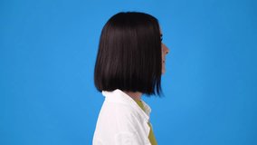 4k video of girl's facial expression on blue background.