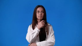 4k slow motion of girl comming up with some idea over blue background.
