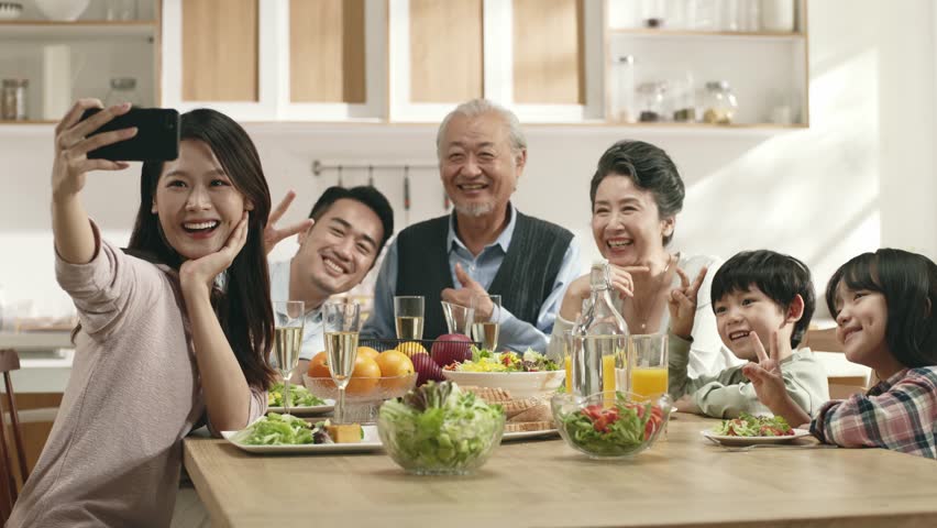 Happy three generation asian family enjoying time together while having meal at home
