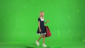 Young girl in casual clothes walking with shopping bags on a Green Screen, Sale day. Woman buyer on Chroma Key. 4k UHD video