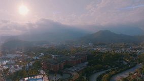 Aerial drone video footage. Resort town on the background of mountains. Sunset sky. Mountains in the background.