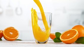 Super slow motion of pouring orange juice into glass. Placed on white table with kitchen interior. Filmed on high speed cinema camera, 1000 fps.  - Powered by Shutterstock - Get 15% off with code: PIKWIZARD15